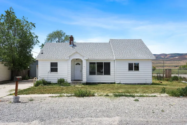 Single-story residence featuring white horizontal siding, an arched entryway, and a light gray shingle roof