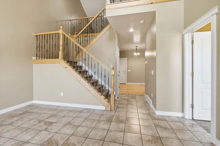 Grand entry with a multi-level staircase featuring wood handrails and decorative wrought iron balusters