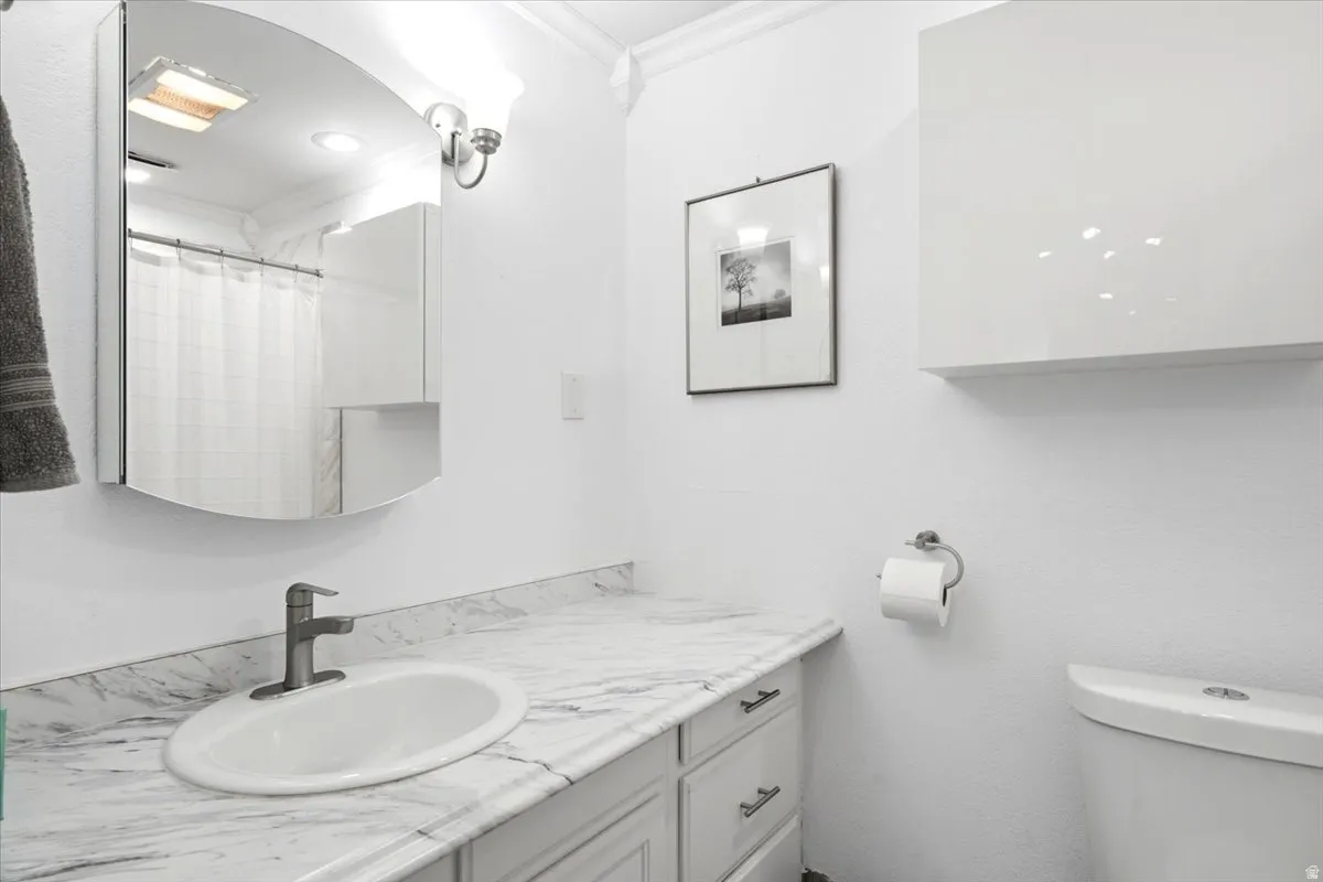 White vanity with a neutral-toned countertop featuring an undermount sink and brushed nickel faucet