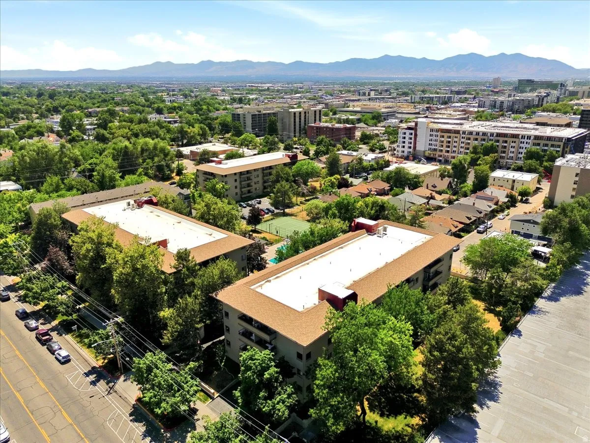 Aerial perspective showcasing two multi-story buildings with brown shingle roofs and light-colored facades