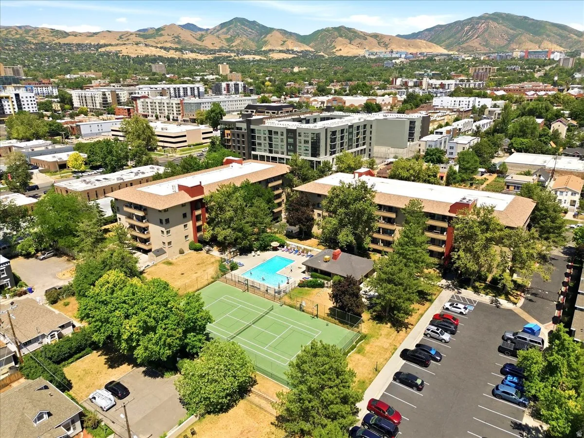 Aerial perspective showcasing a tennis court, and an outdoor swimming pool