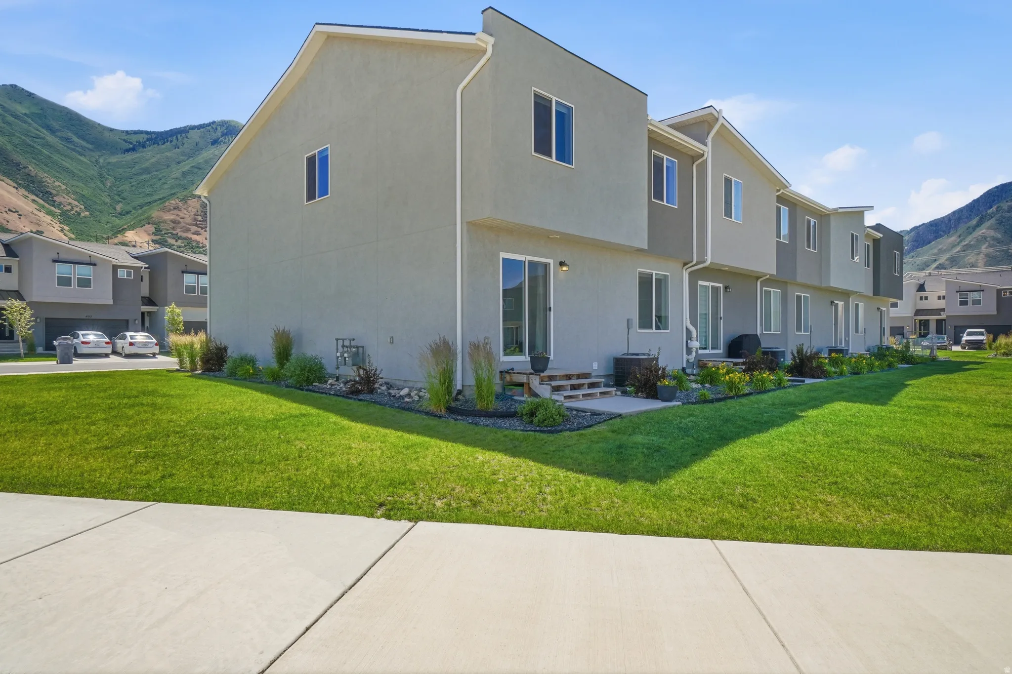 Rear exterior showcasing multiple units with private patios and sliding glass doors