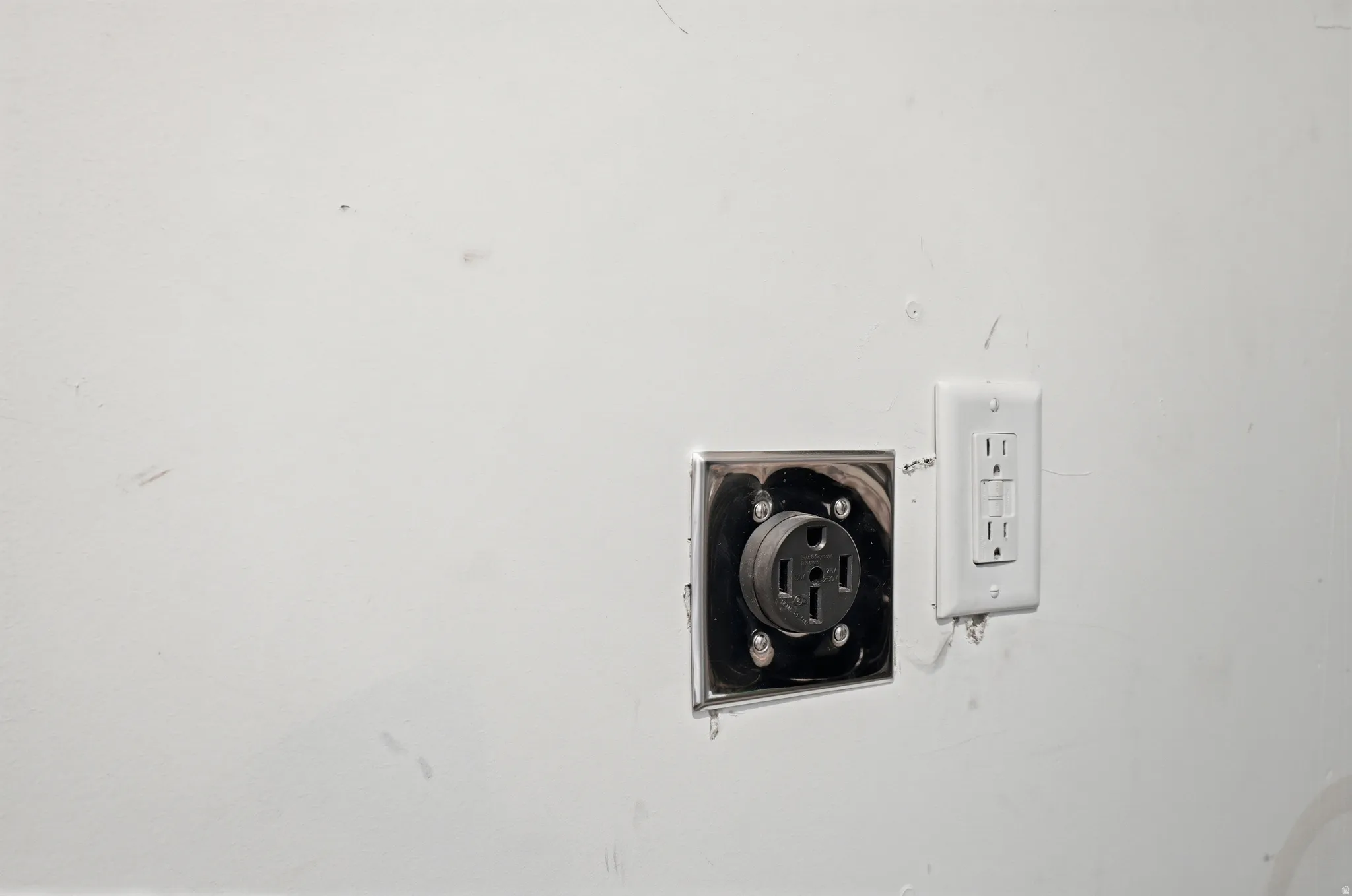 Electrical outlet and GFCI receptacle on a white wall