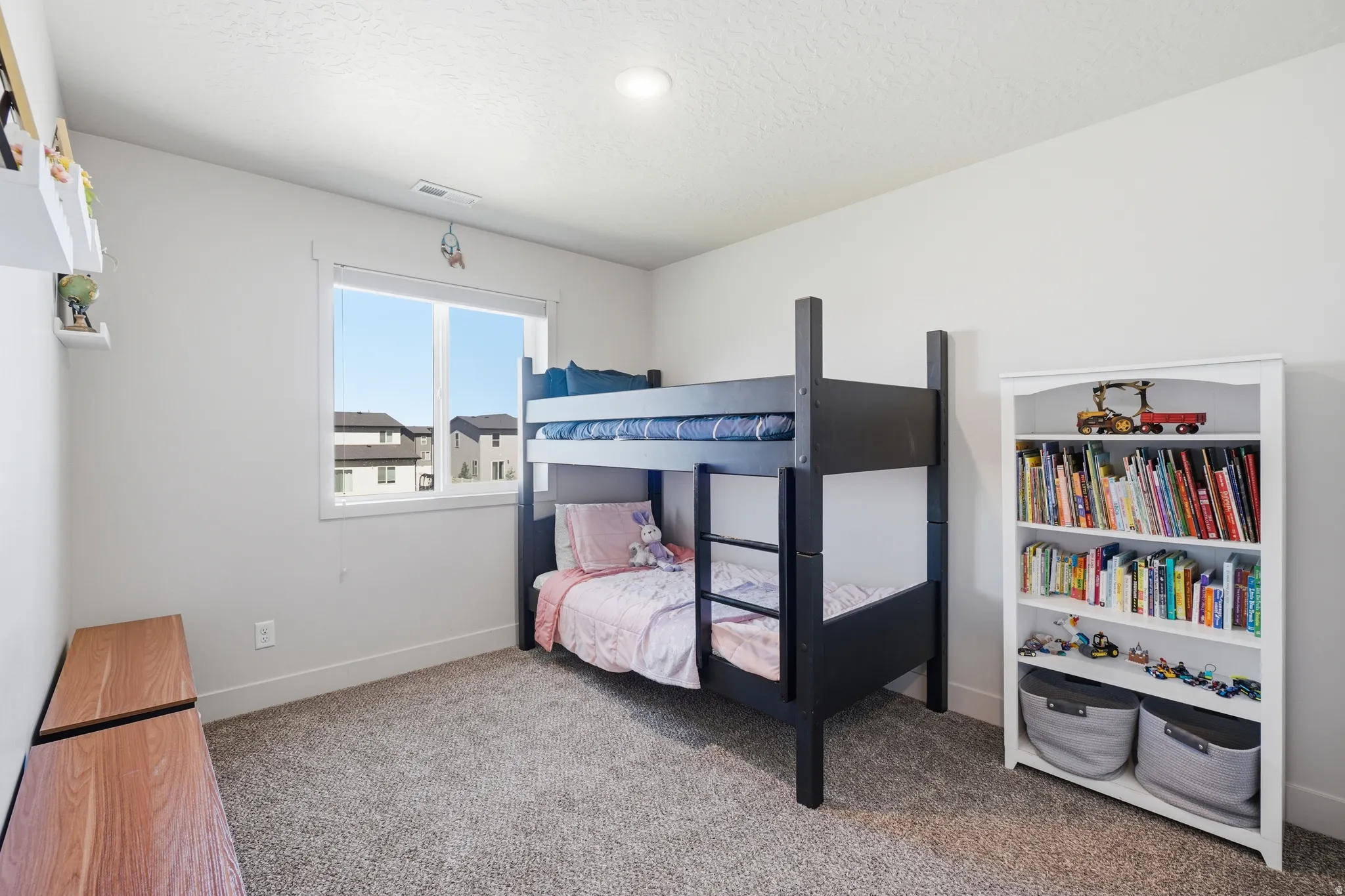 Bright room with plush carpeting, a large window, recessed lighting, and white walls