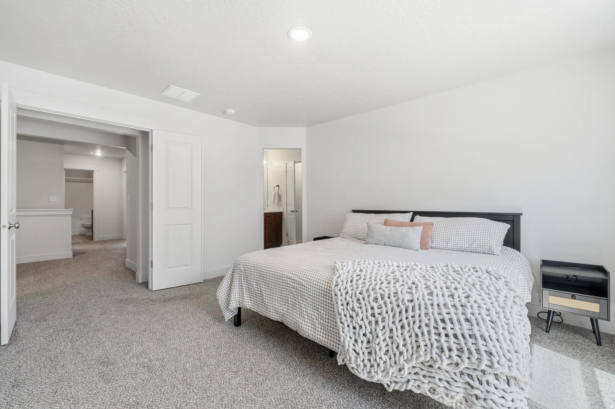 Carpeted room with a ceiling-mounted light fixture, white walls, and a white paneled door