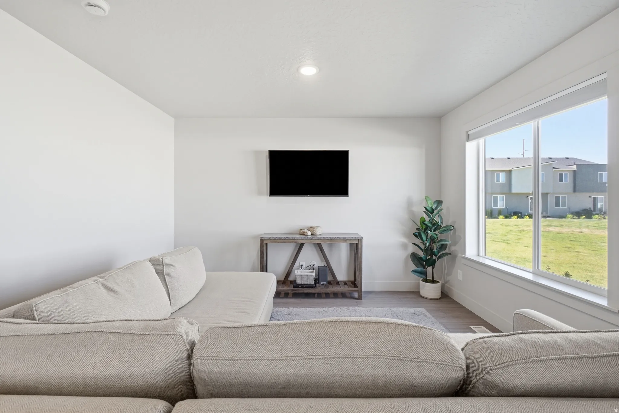 Living area featuring a large picture window, recessed lighting, and light wood-finish flooring
