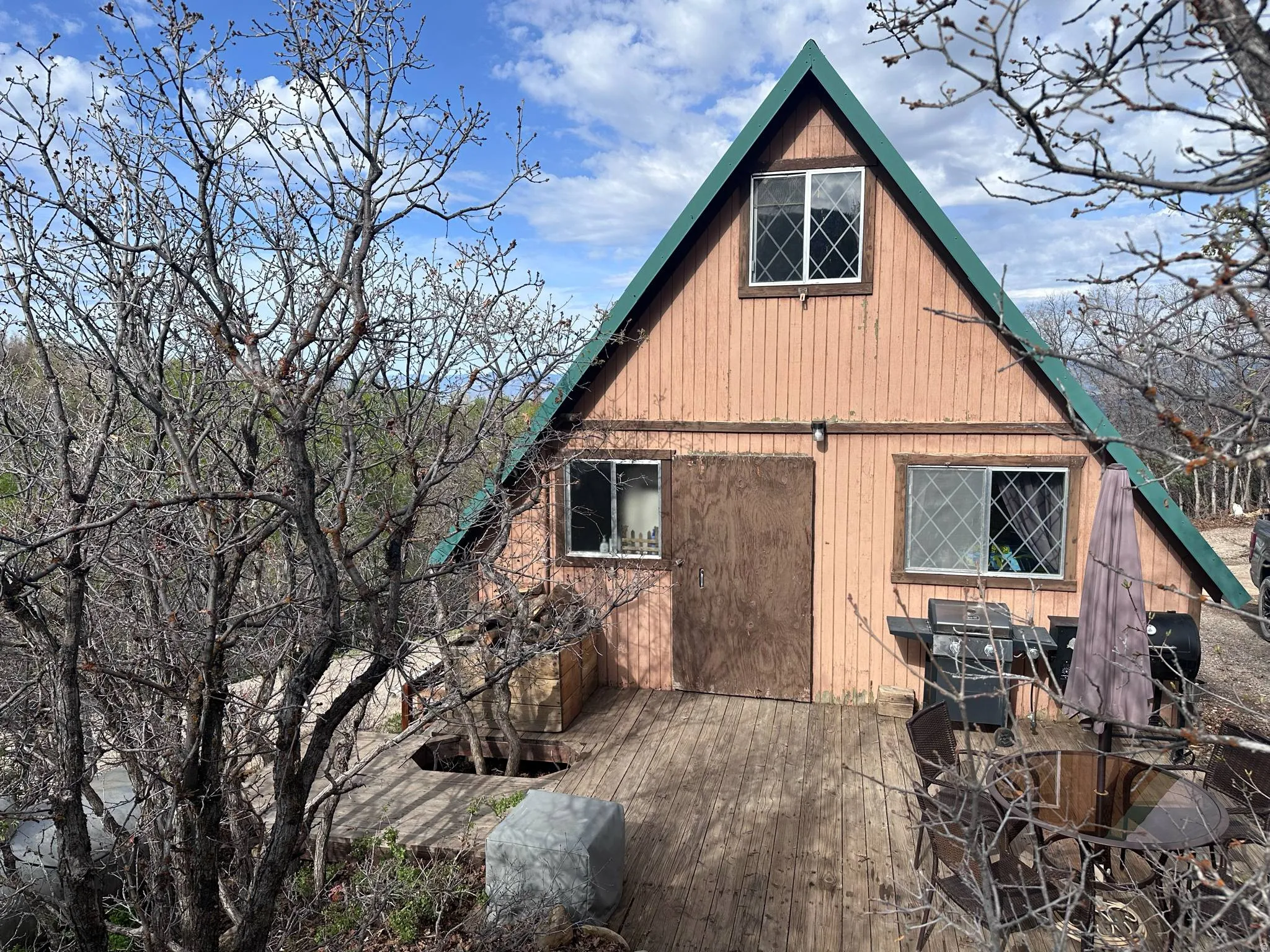 A-frame exterior with vertical wood siding and a green-trimmed roofline