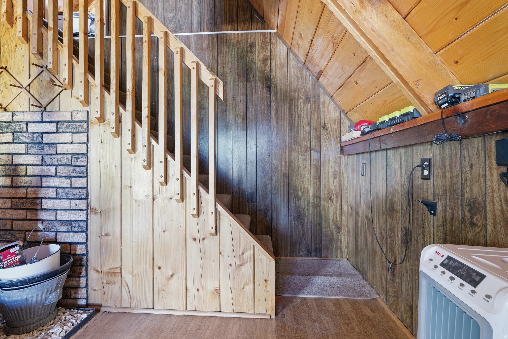 Staircase featuring natural wood balusters and a wood-panel accent wall