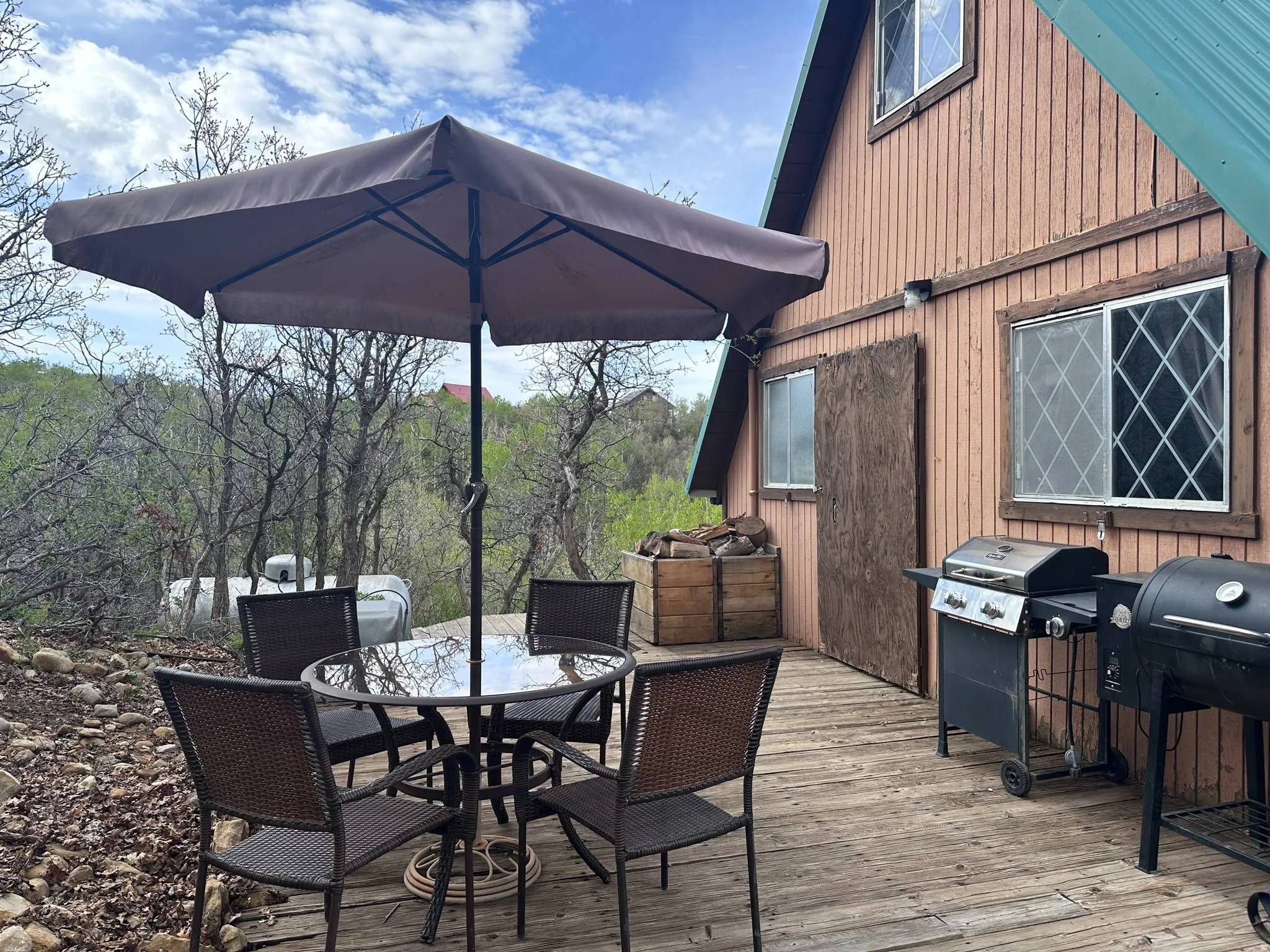 Wood-finish exterior featuring a metal roof, diamond-pane windows, and a spacious outdoor deck
