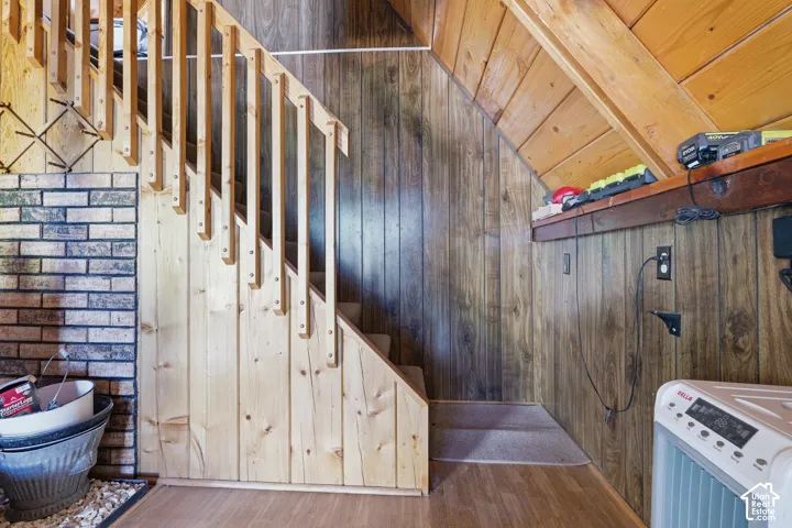 Staircase featuring natural wood balusters and a wood-panel accent wall