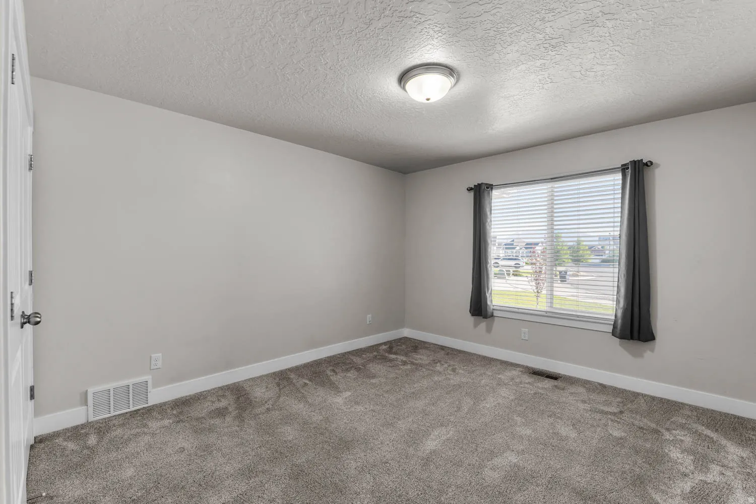 Light gray wall paint, gray carpeting, and white trim