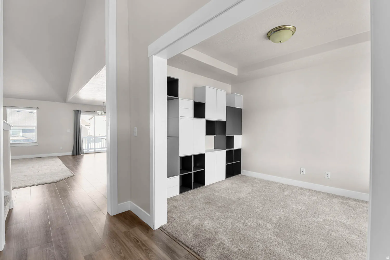 Carpeted room featuring a built-in modular shelving unit with white and dark gray cubbies