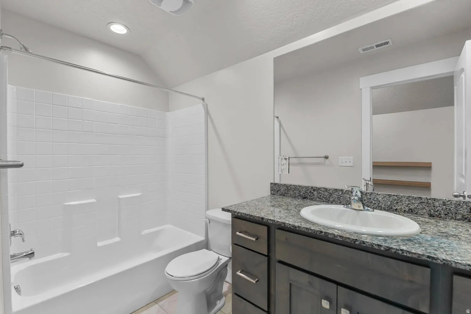 Bathroom featuring a shower-tub combination with white subway tile surround