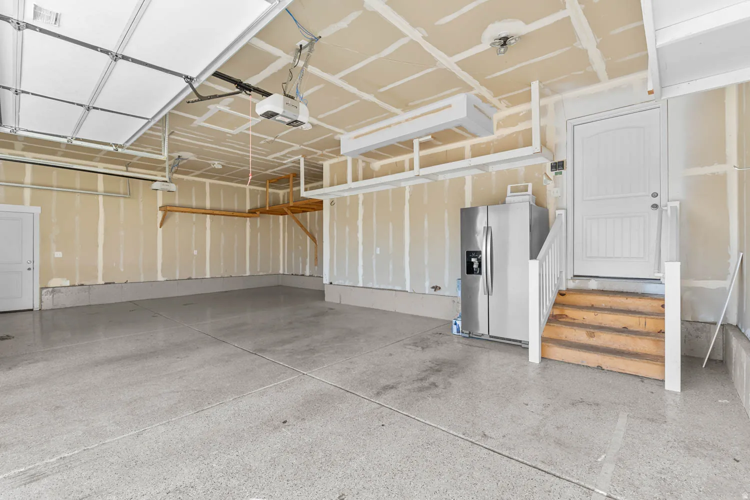 Spacious two-car garage featuring an epoxy-coated concrete floor and an automatic garage door opener