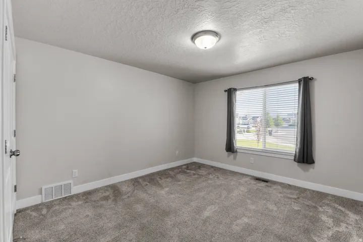 Light gray wall paint, gray carpeting, and white trim