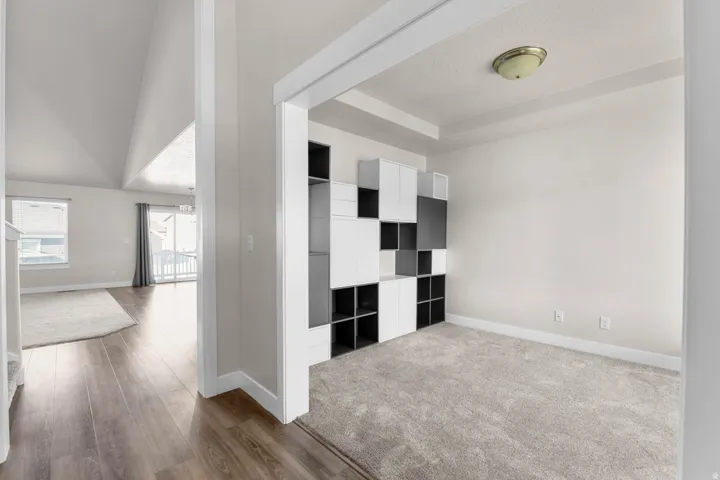 Carpeted room featuring a built-in modular shelving unit with white and dark gray cubbies