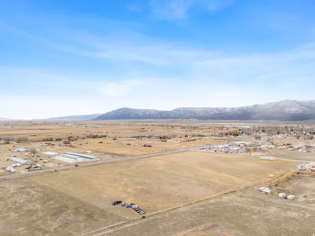 Expansive land parcel featuring agricultural greenhouses and distant mountain ranges