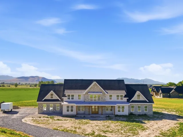 Expansive residential structure featuring stone and siding exterior with multiple gables