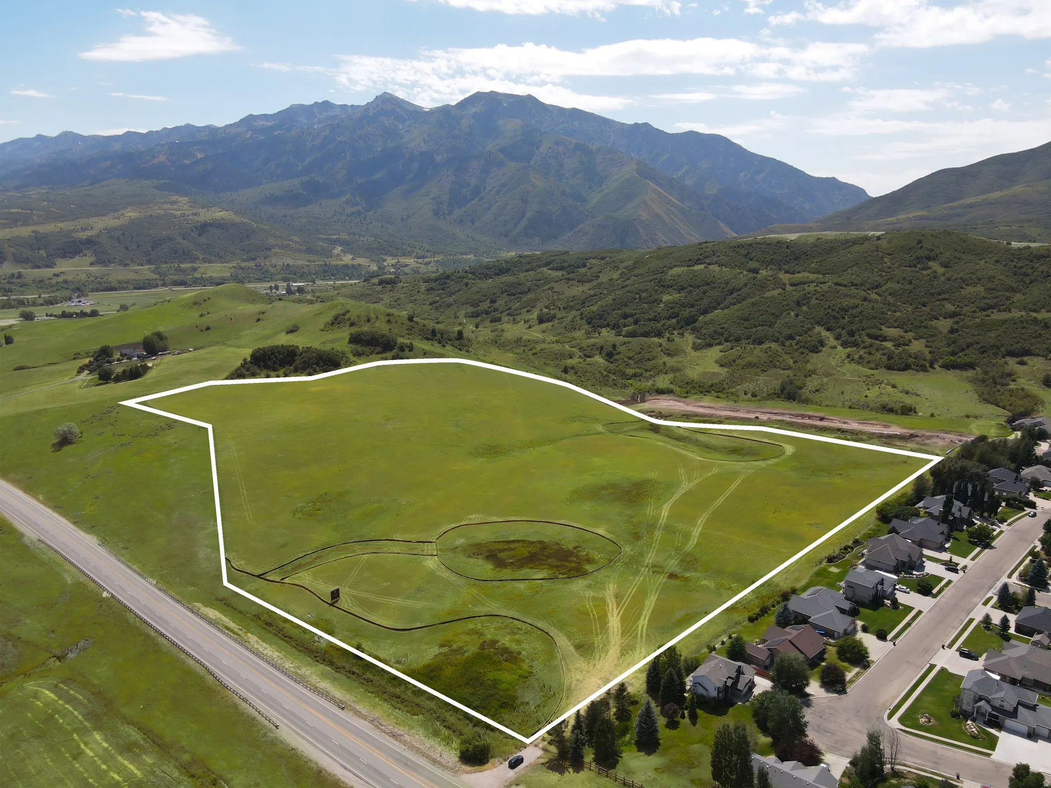 Expansive, undeveloped land parcel featuring a lush green field