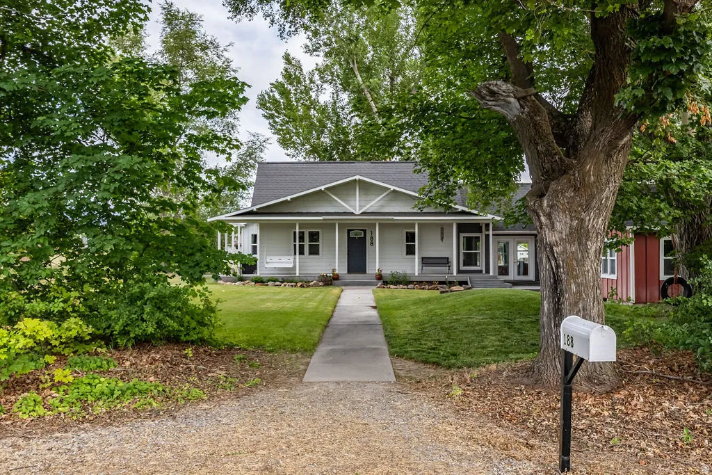 Ranch-style residence featuring a covered porch, dark gray entry door, and white trim