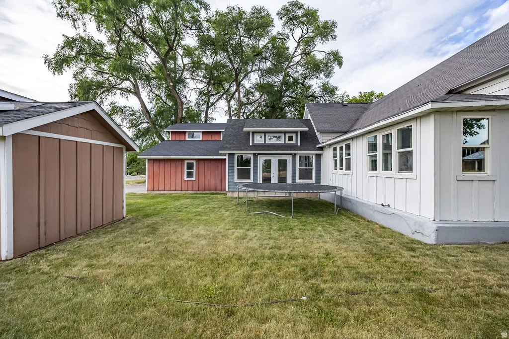 Rear exterior featuring a white board and batten siding section, a grey siding section with white trim, and a red siding section