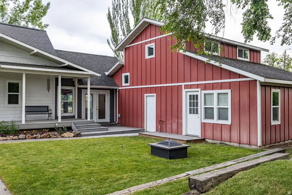 Exterior featuring a red board-and-batten section with white trim, a light-colored horizontal siding section, and dark gray roofing