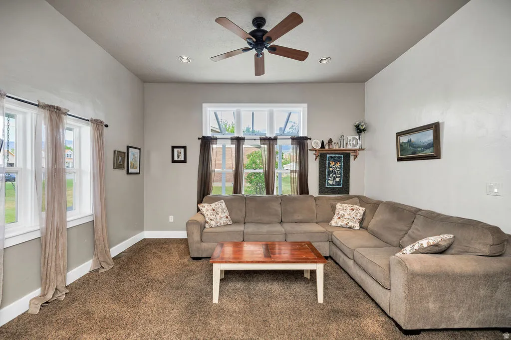 Living area featuring multiple windows, recessed lighting, a ceiling fan, and neutral wall tones