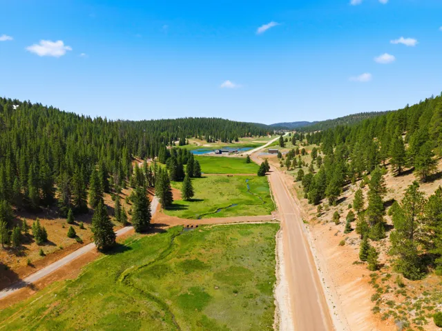 Expansive rural landscape featuring a dirt road traversing through a valley