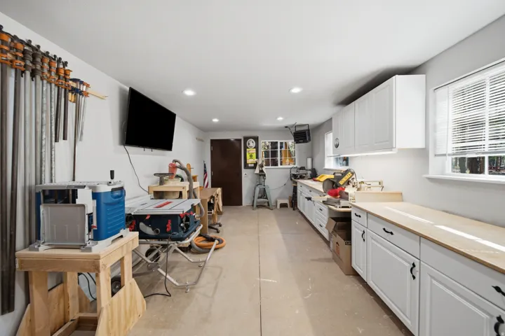 Spacious workspace with extensive built-in cabinetry, durable countertops, and recessed lighting