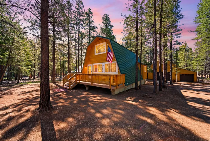 Unique A-frame structure with wood siding and a green metal roof