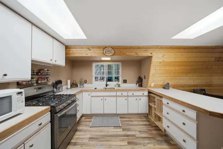 Kitchen featuring wood-finish flooring and white cabinetry