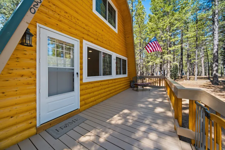A-frame exterior featuring horizontal log siding and a spacious wood deck