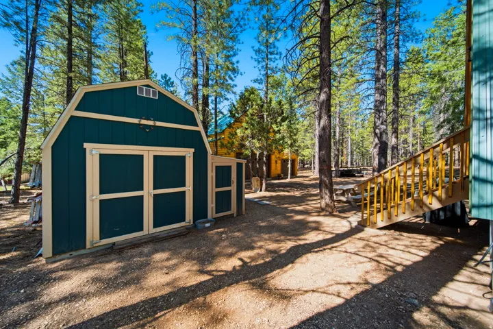 Barn-style storage shed with a gable roof and dual front doors