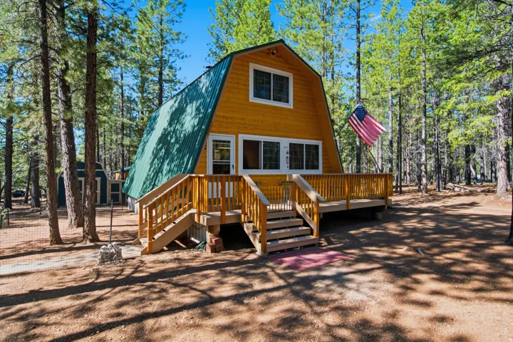 A-frame style residence with yellow siding and a green metal roof