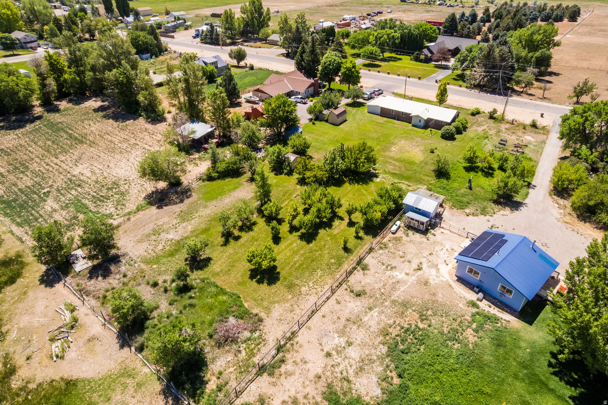 Aerial perspective showcasing a vibrant blue-roofed residence with solar panels