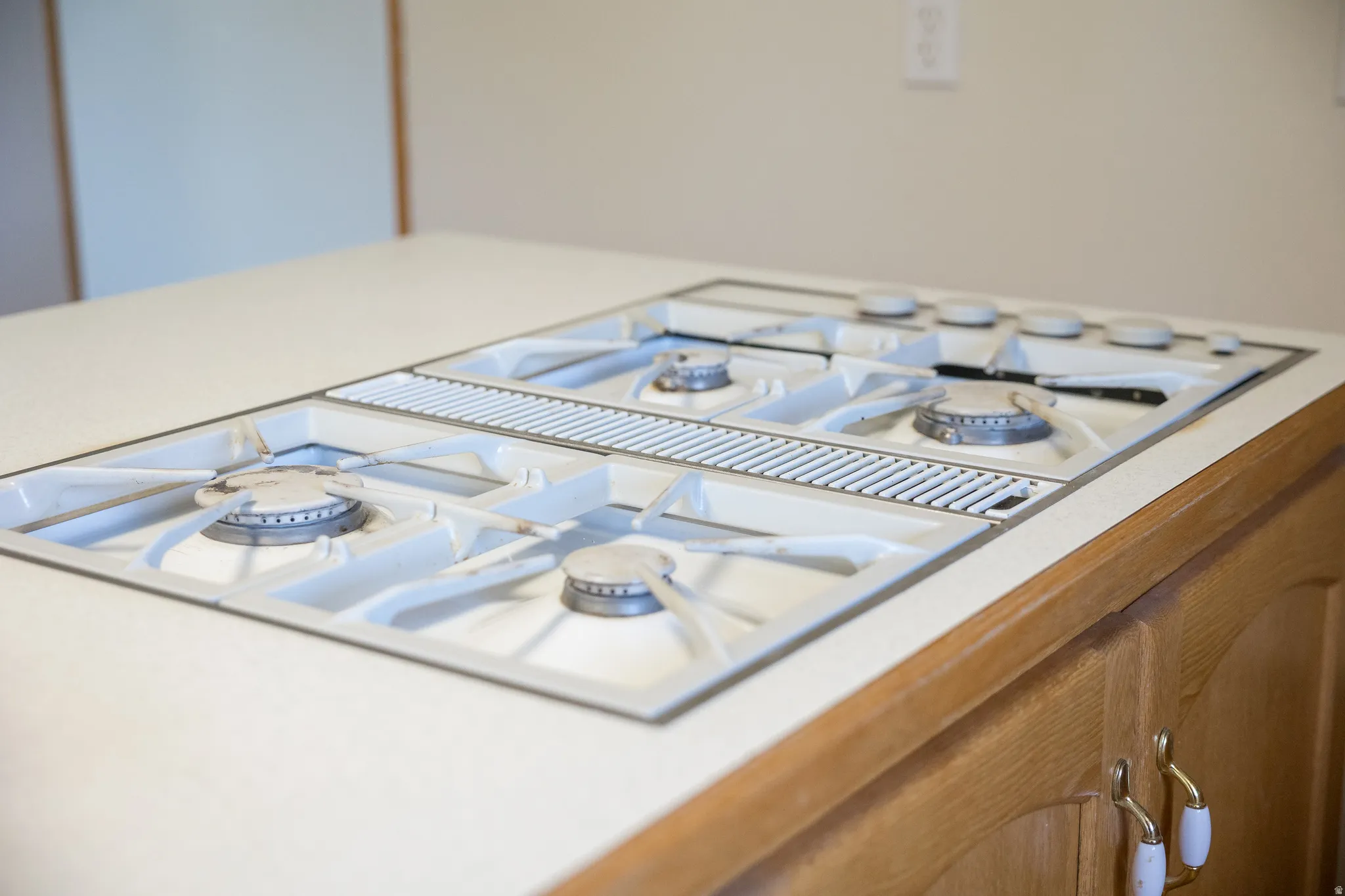 Built-in gas cooktop with four burners and an integrated downdraft ventilation system