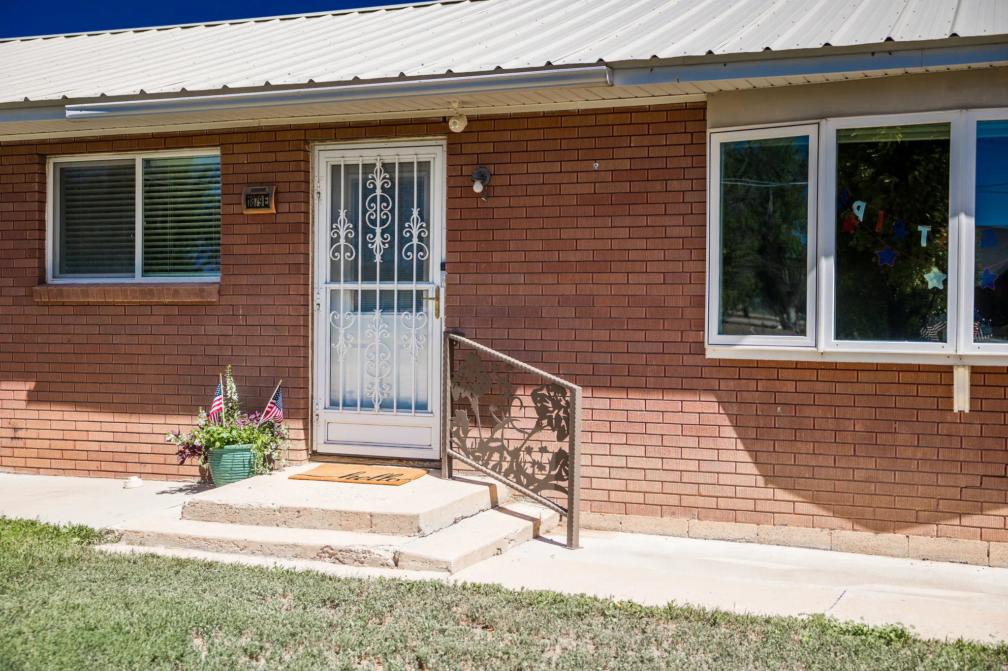 Brick exterior with white trim windows and a metal roof