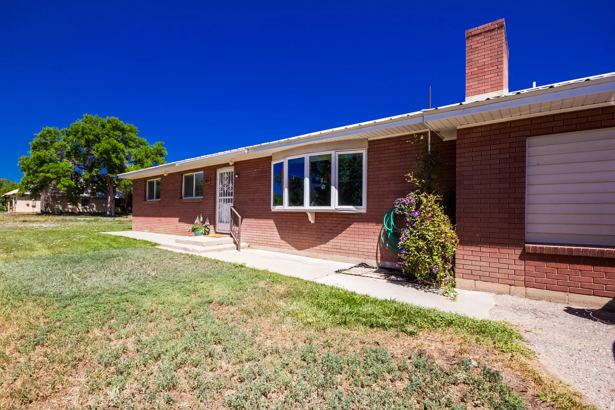 Red brick exterior featuring white trim and a prominent chimney