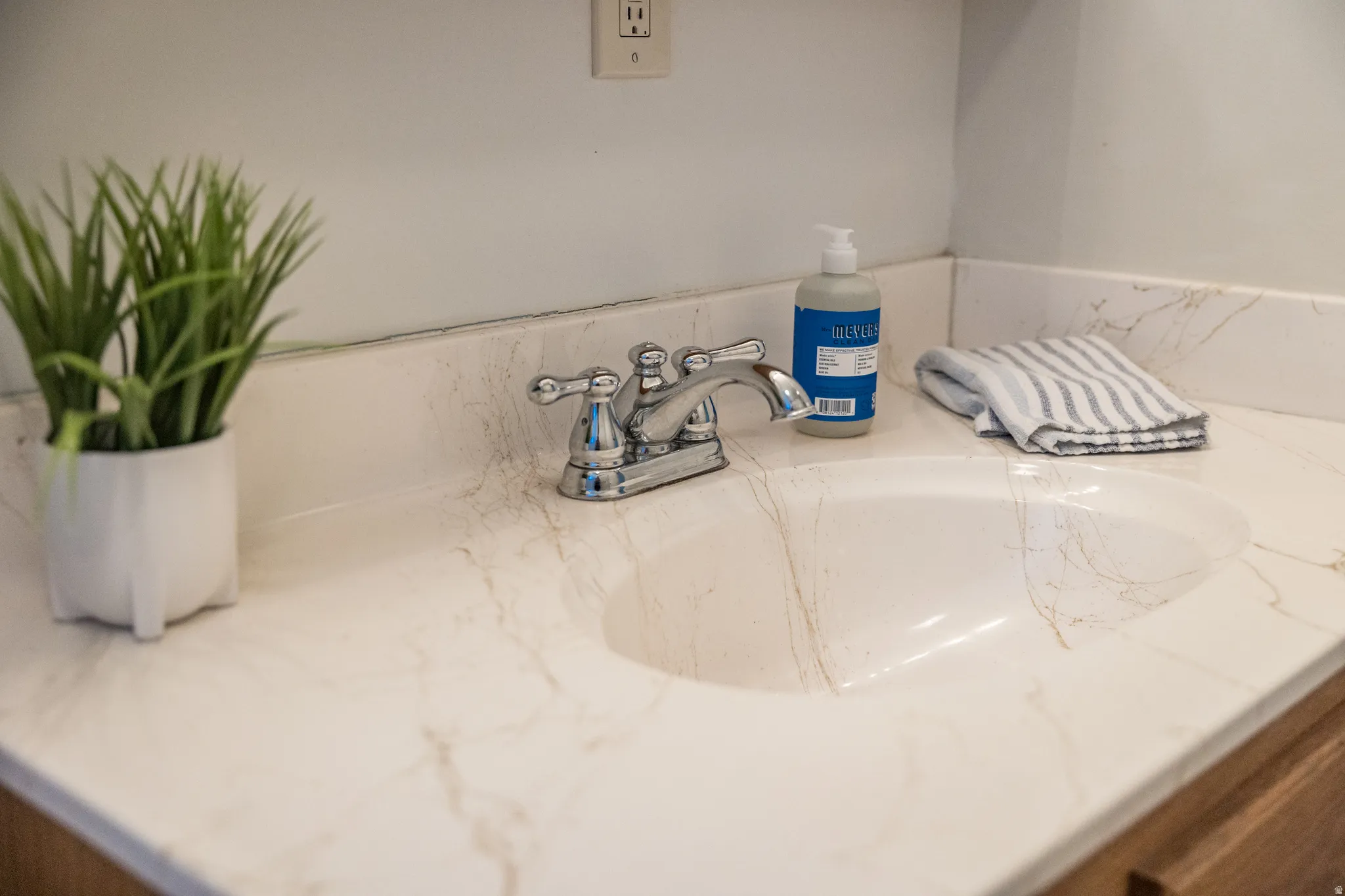 Integrated vanity with a polished chrome faucet and an oval sink, set against a light wall