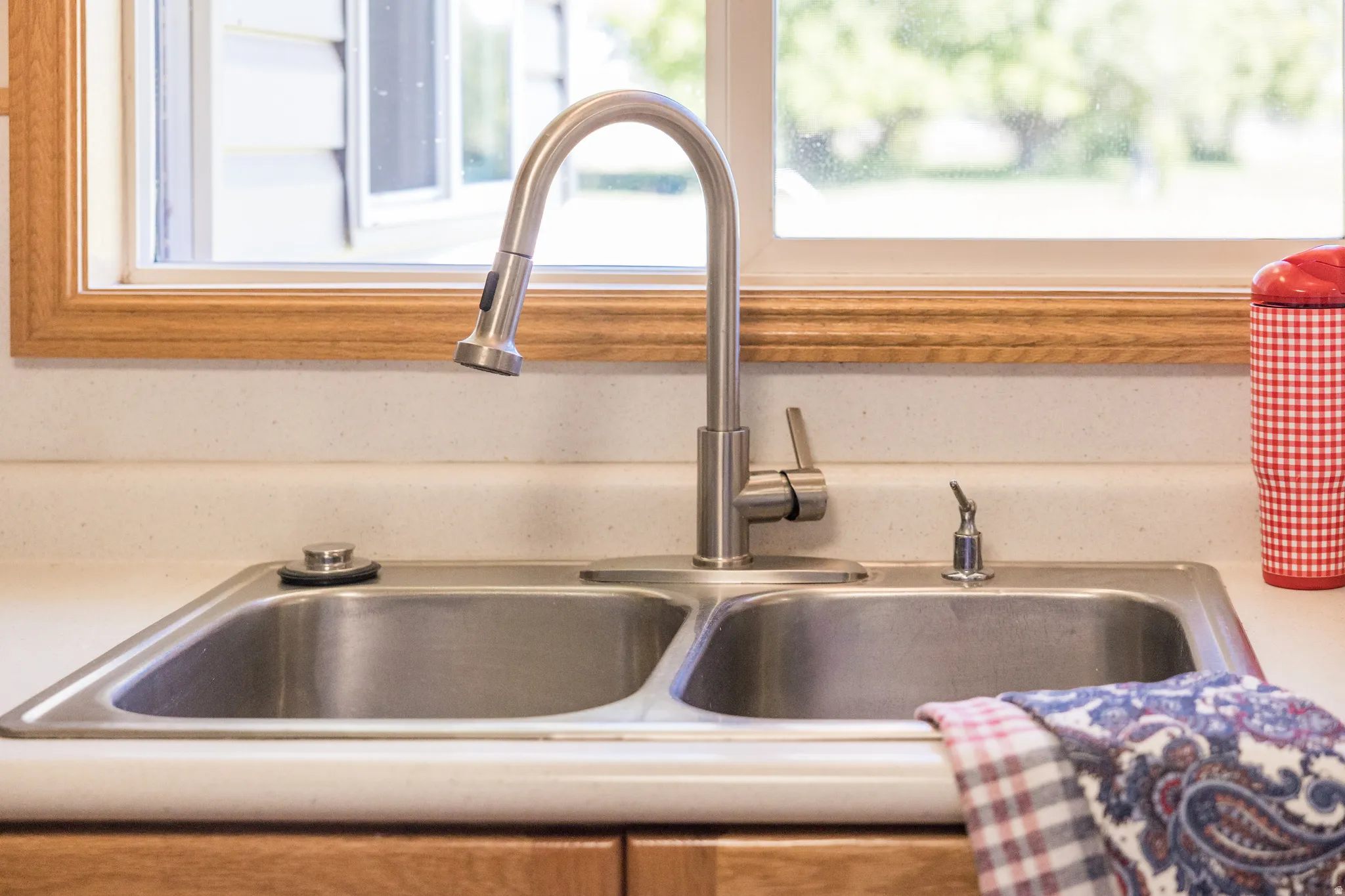 Dual-basin stainless steel sink with a gooseneck pull-down faucet