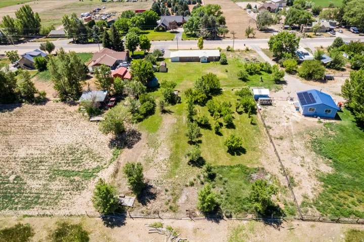Expansive property featuring a mix of cultivated and natural terrain, bordered by fencing