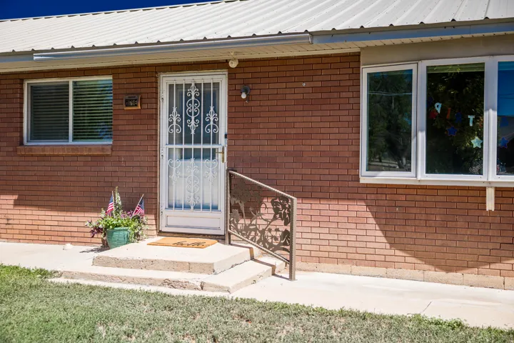 Brick exterior with white trim windows and a metal roof