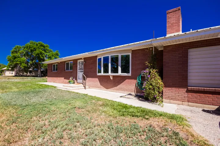 Red brick exterior featuring white trim and a prominent chimney