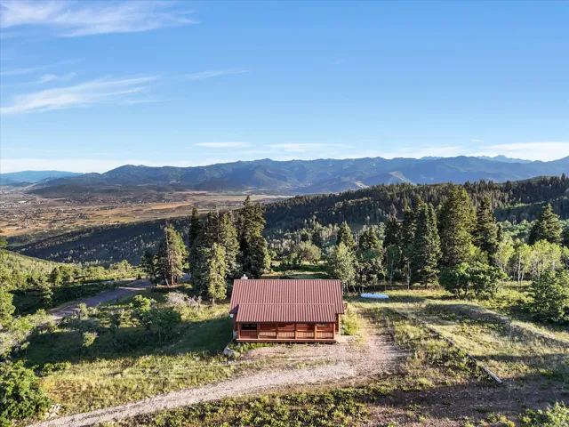 Log cabin residence featuring a metal roof, log siding, and a wooden porch