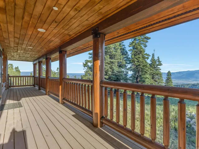 Expansive covered porch featuring wood-finish ceiling, recessed lighting, and a composite deck surface