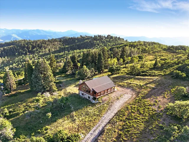 Log cabin style residence with a gabled roof and a stone foundation