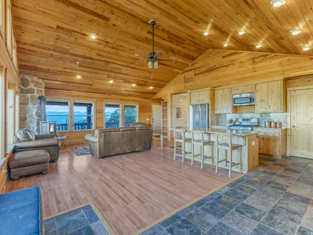 Spacious room featuring wood-finish flooring, vaulted wood-paneled ceilings, and recessed lighting