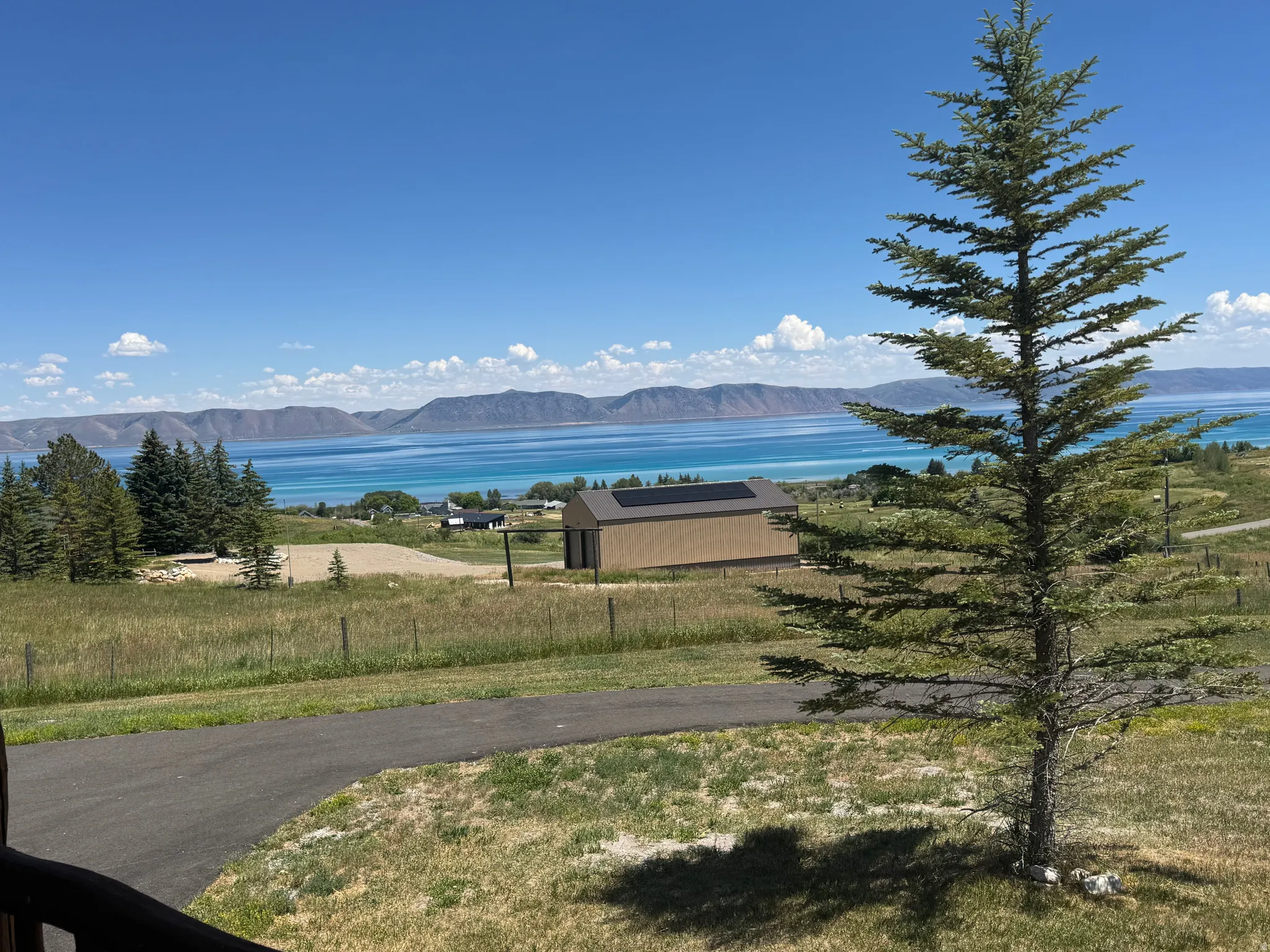 Expansive landscape featuring a large body of water, distant mountains, and a clear sky