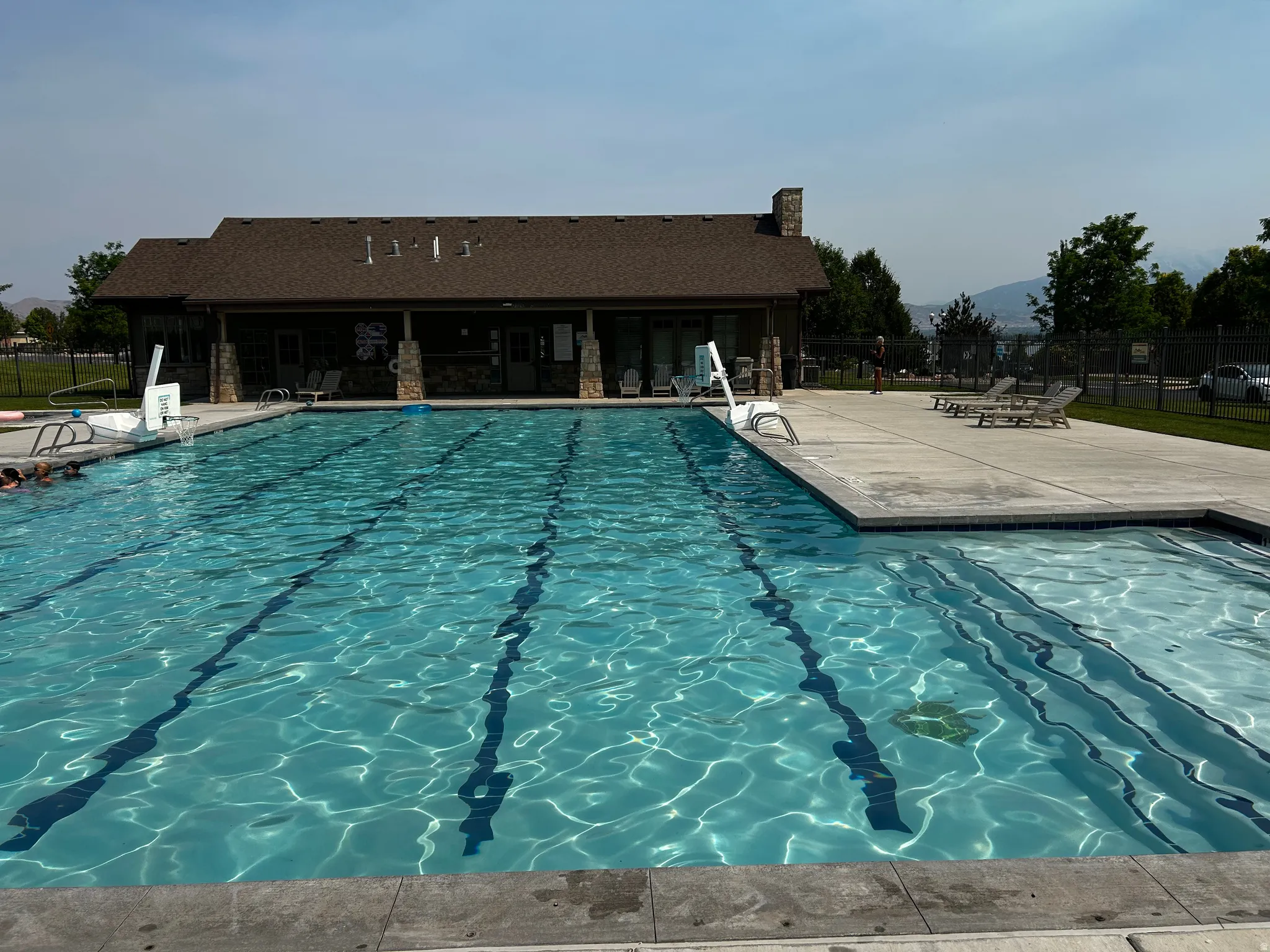Community pool featuring multiple swimming lanes, integrated steps for entry, and a broad concrete deck