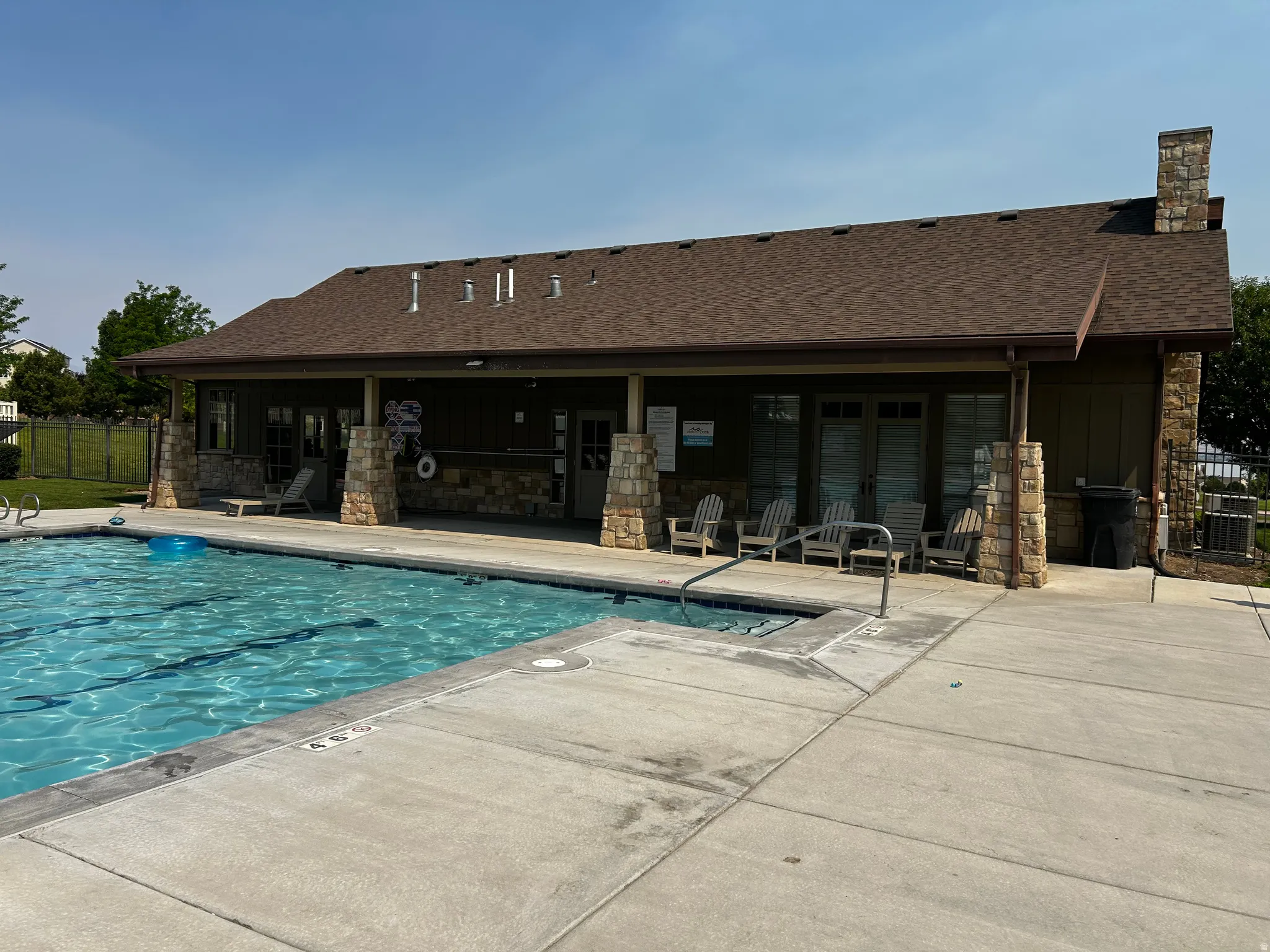 Outdoor swimming pool with integrated spa and concrete decking